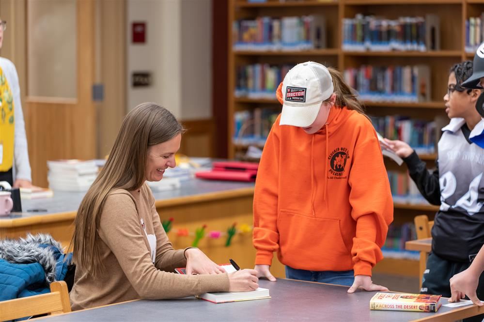 Author Dusti Bowling signing books for Pulaski Middle School students.