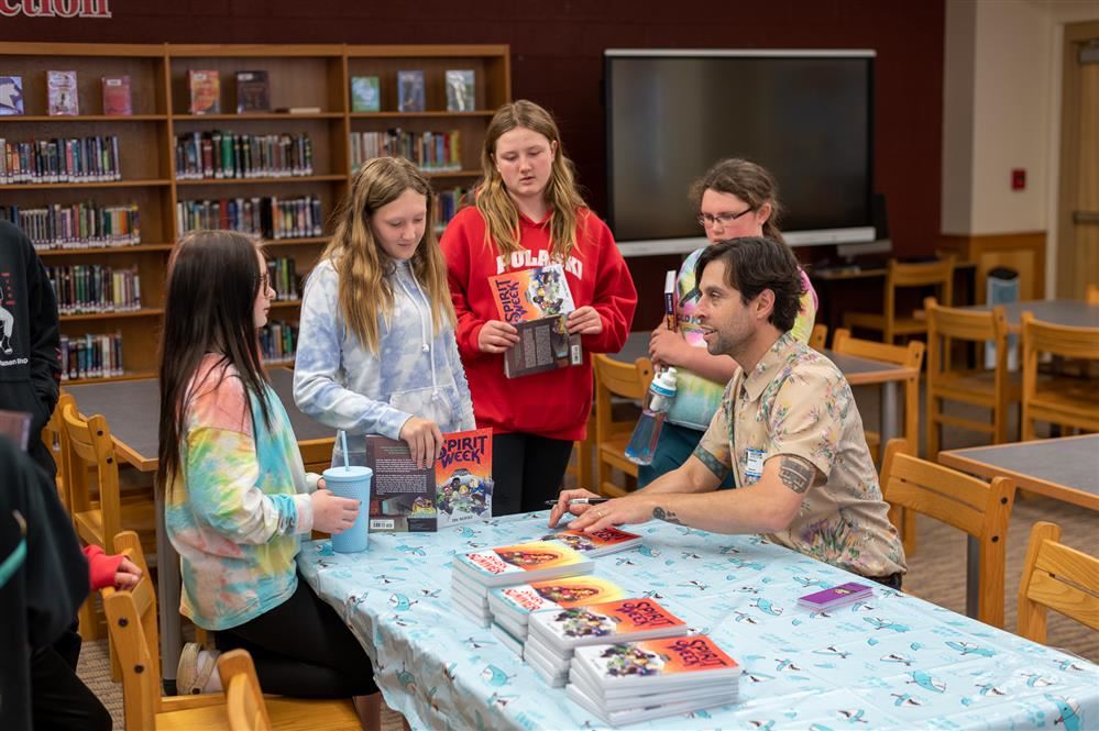 Ira Marcks signing books for Pulaski Middle School students 