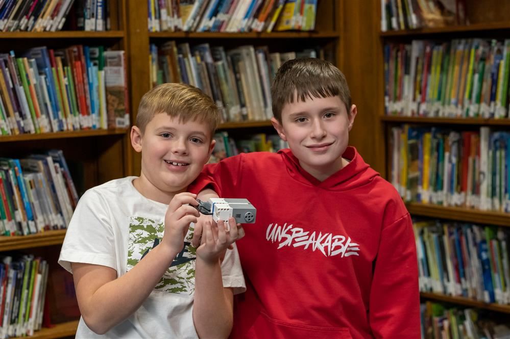  Students in Lura Sharp Elementary’s Robotics Club proudly show off the robot they built.